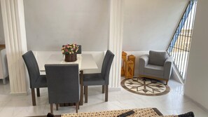A dining area with a table, chairs, and a flower vase.