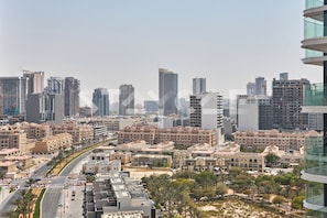 Un paisaje urbano con edificios modernos altos, una avenida amplia y una combinación de construcciones residenciales y comerciales.