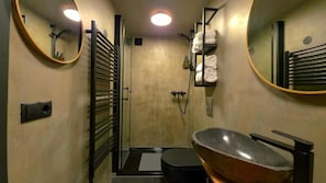 Une salle de bain équipée d’une baignoire, d’une douche, de toilettes et d’un porte-serviettes.