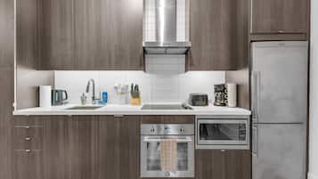 A modern kitchen with wooden cabinets, a stainless steel range hood, a built-in oven, a microwave, and a refrigerator.
