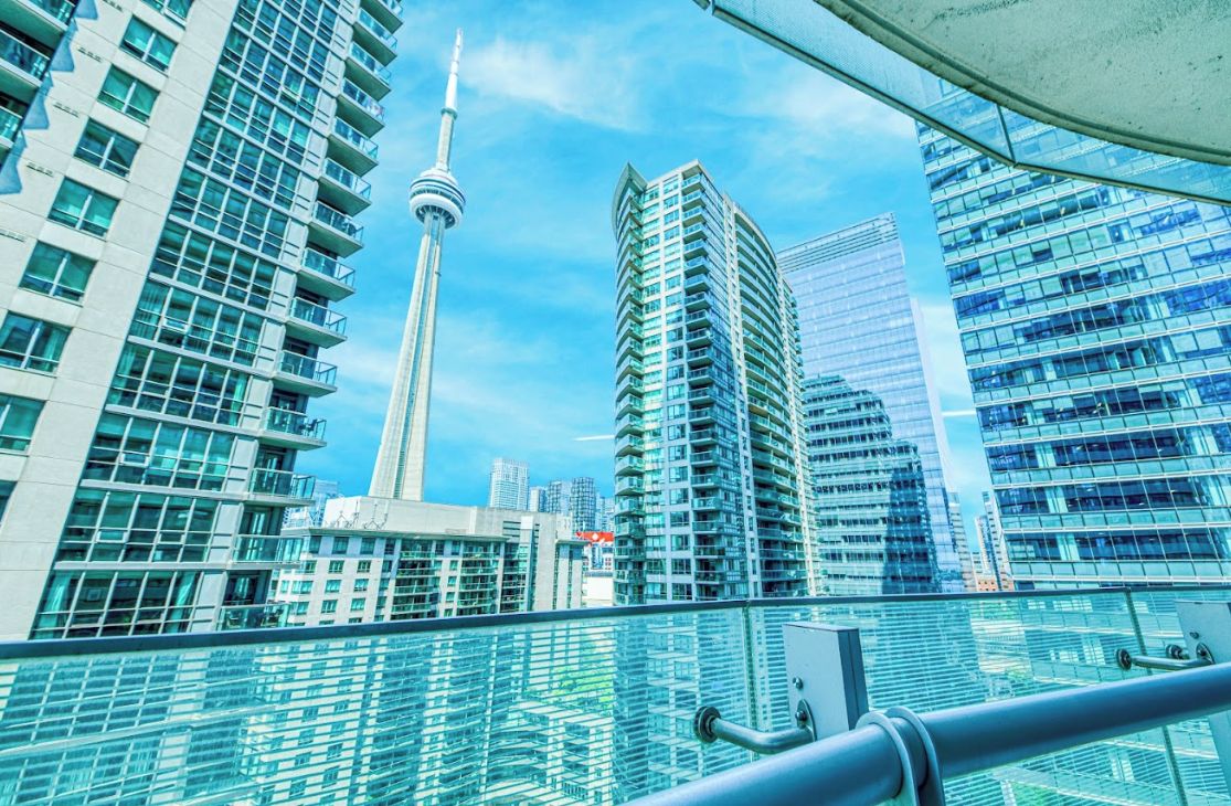 A cityscape with modern high-rise buildings, a prominent tower, and a clear sky.