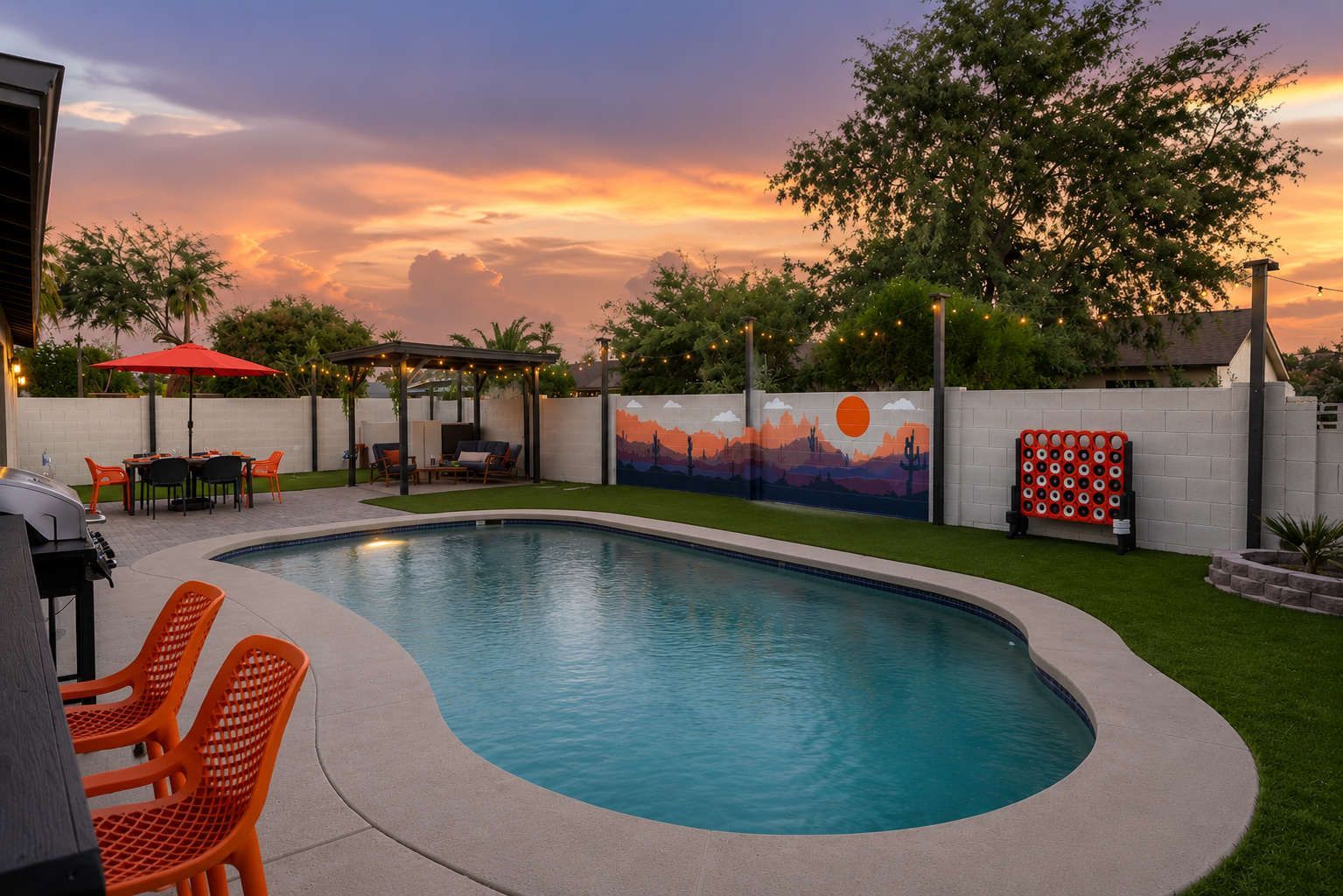 Un jardin avec une piscine, un espace salon extérieur et une fresque murale.