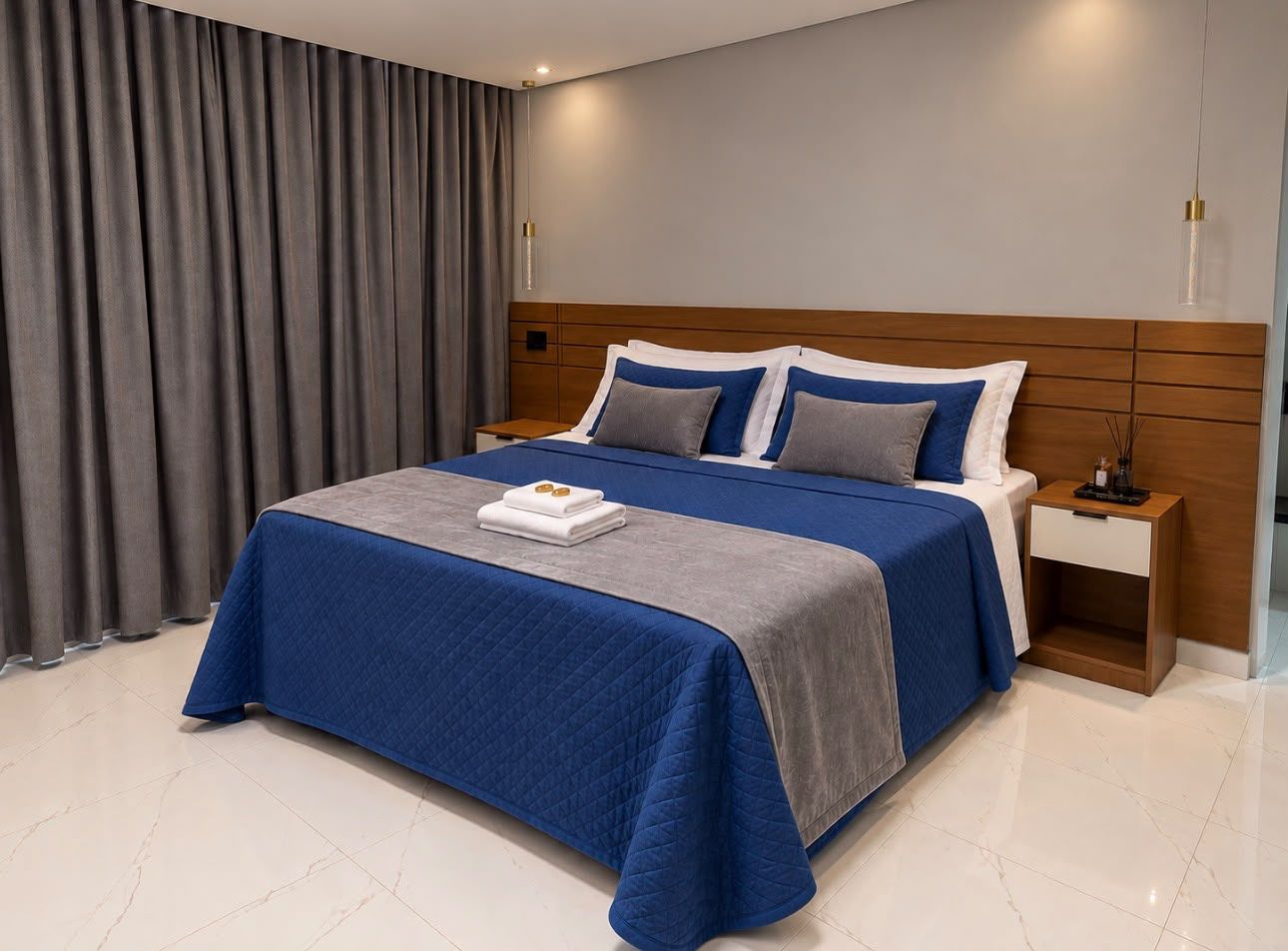 Habitació d'hotel moderna amb un llit gran, una tauleta de nit i vistes a la ciutat.
