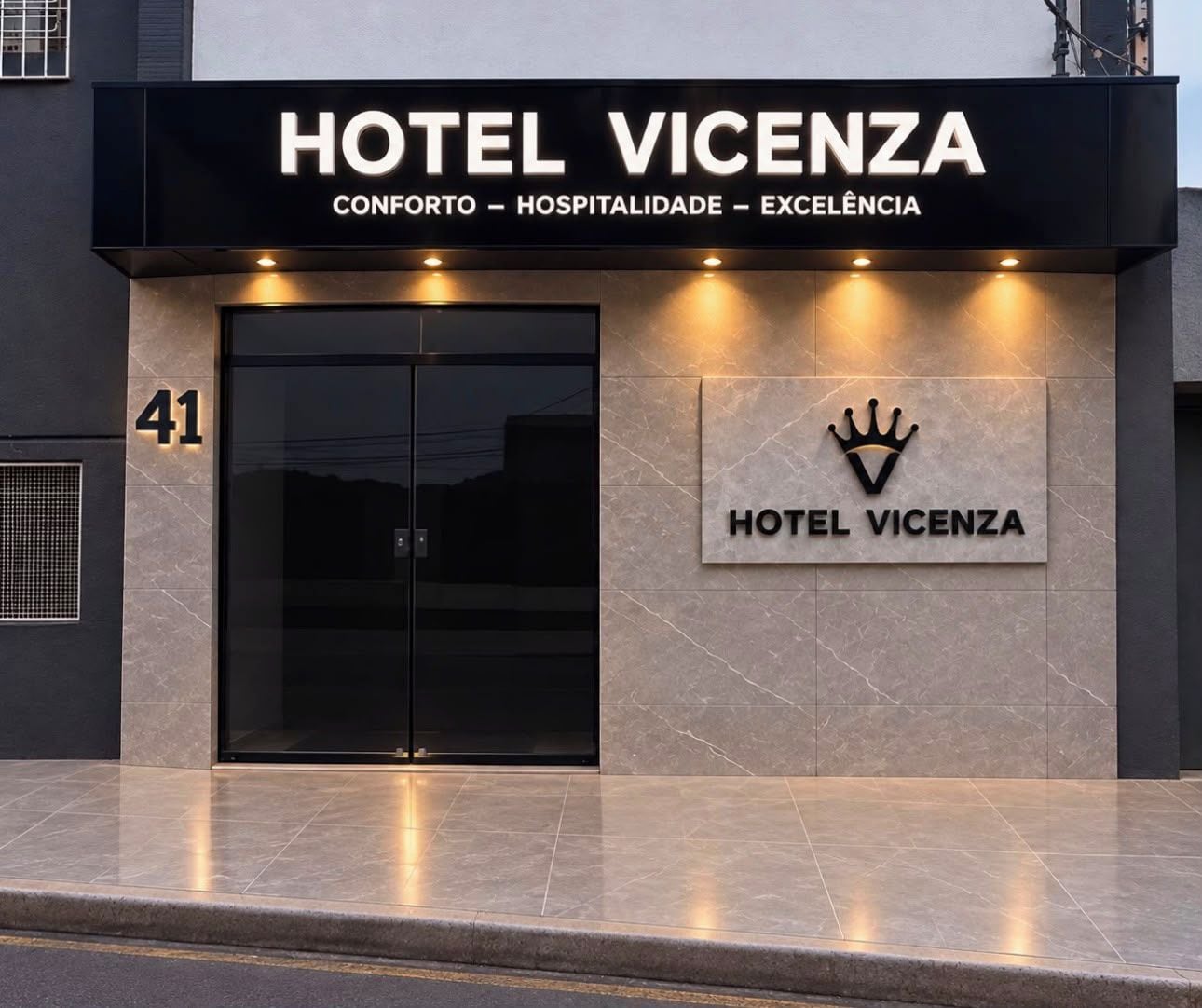 Façana moderna d'un hotel amb una entrada destacada, un logotip de corona i el nom 'HOTEL VICENZA' mostrat sobre les portes.