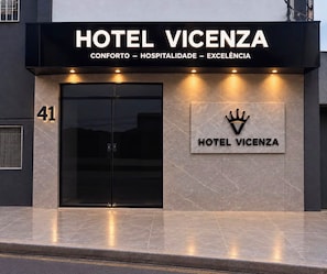 A modern hotel facade with a prominent entrance, a crown logo, and the name 'HOTEL VICENZA' displayed above the doors.