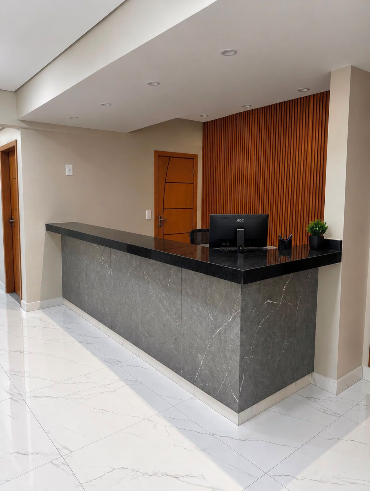Una taquilla de recepció amb un taulell de marbre, una paret revestida de fusta i una porta al fons.