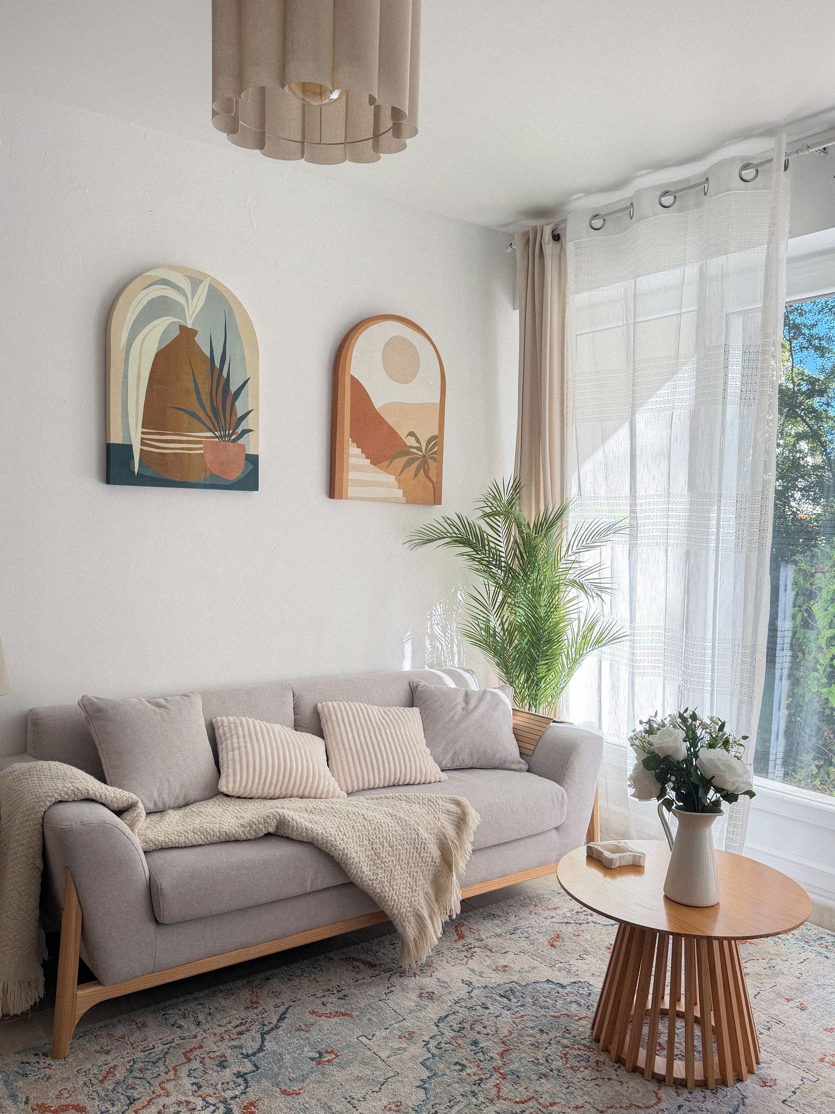 Ein modernes Wohnzimmer mit einer Couch, einem Couchtisch und zwei Wandbildern.