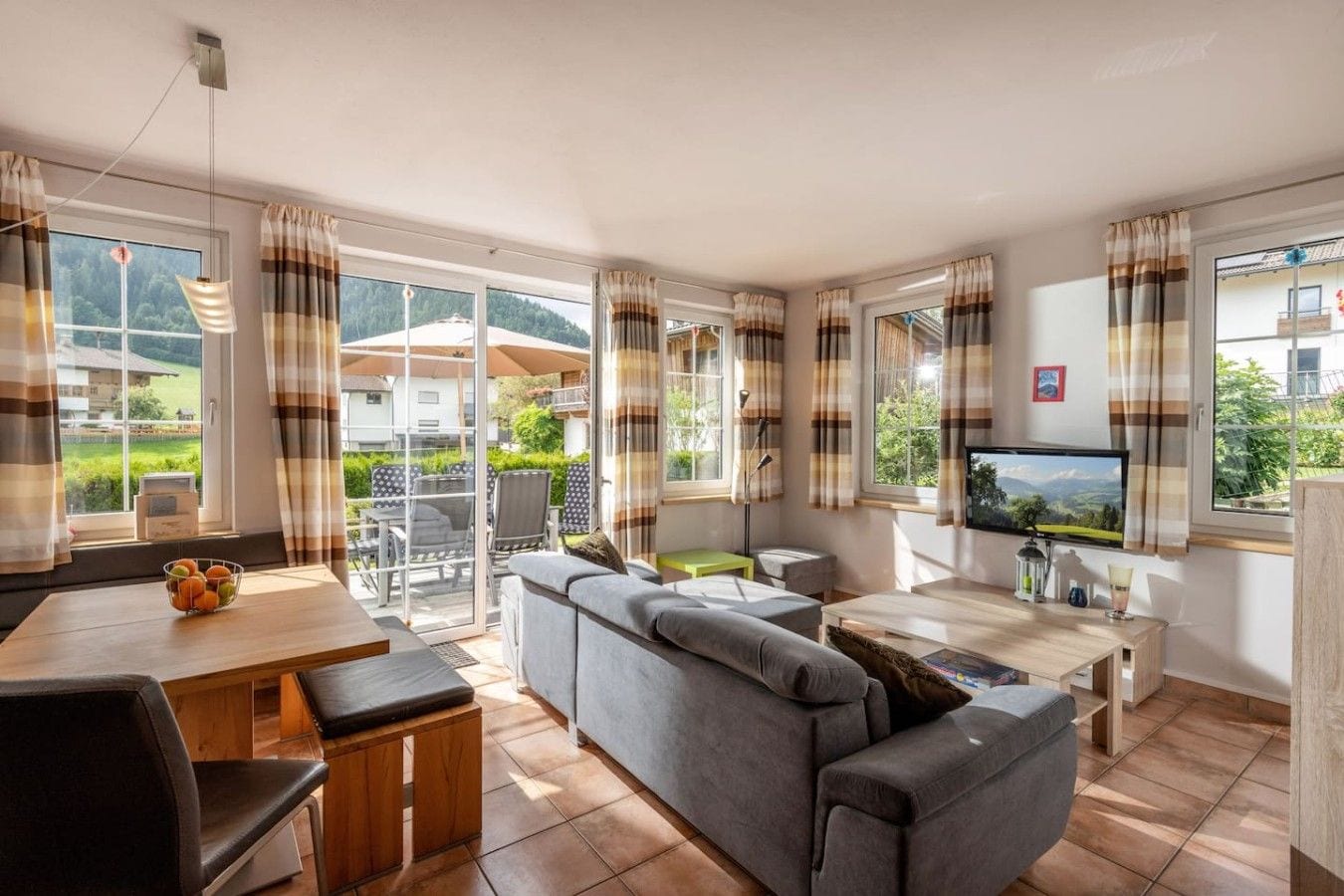 A living room with a sofa, a dining table, and a TV.