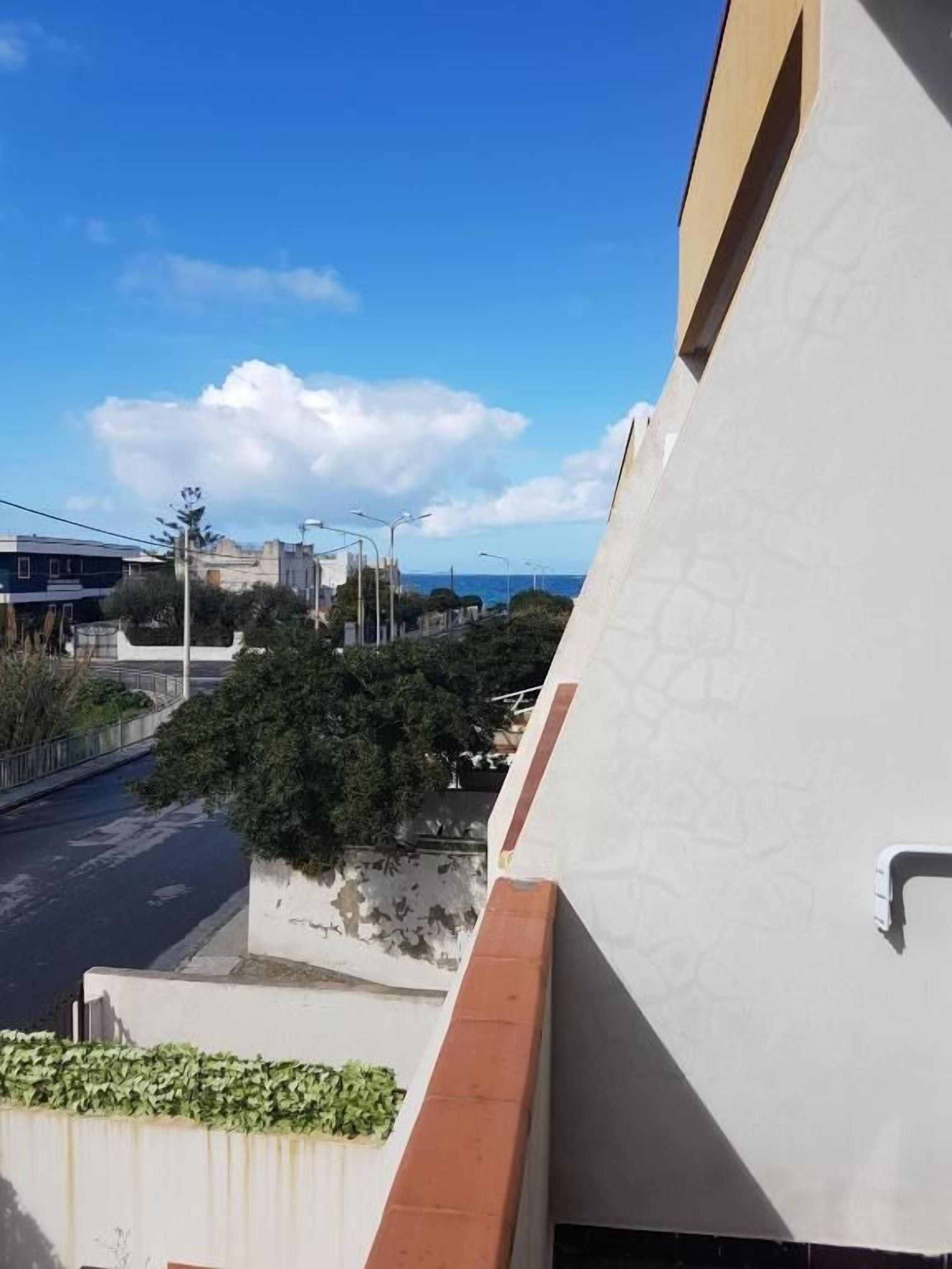 Un edificio con fachada blanca y balcón visible.