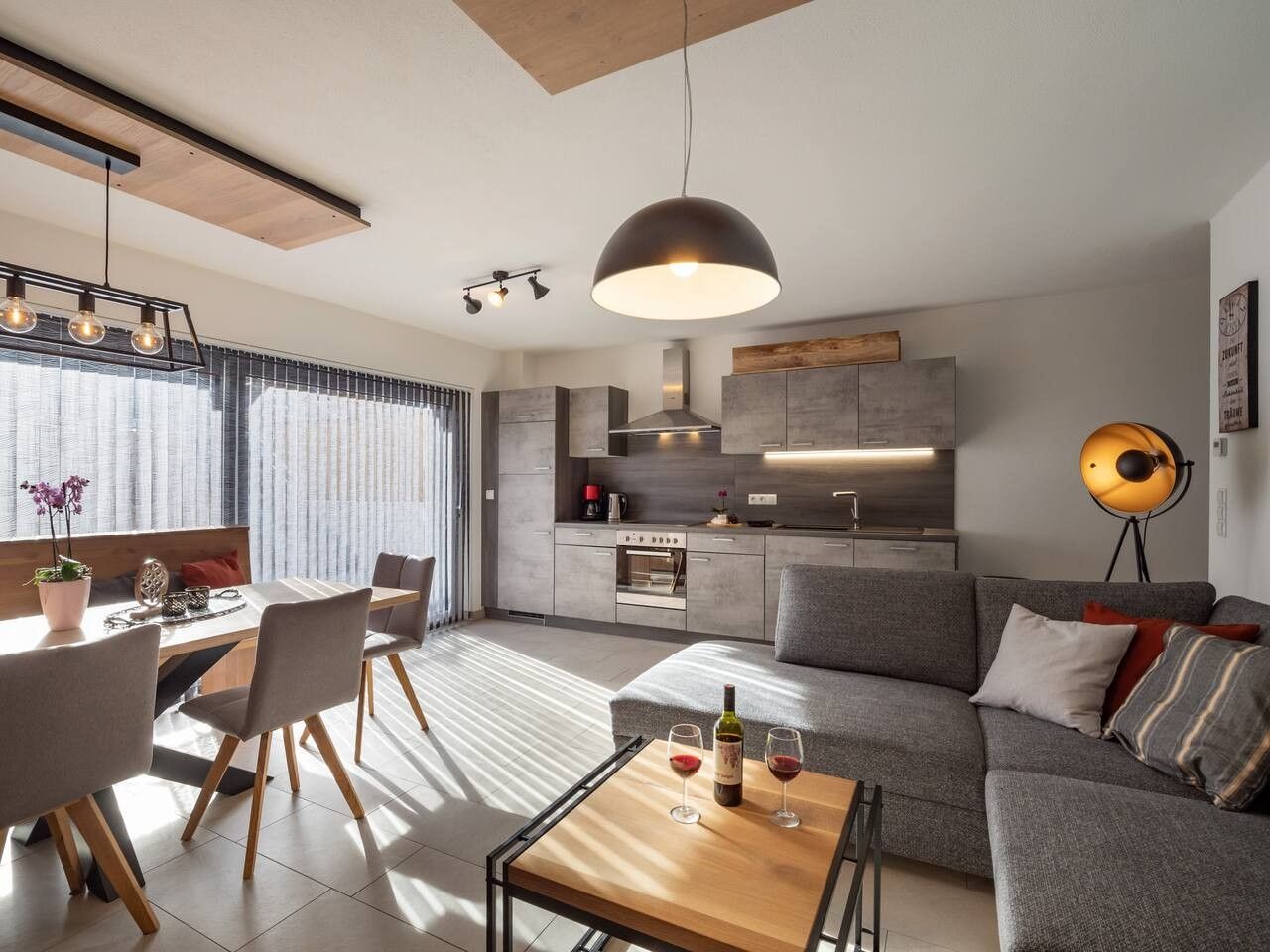 A modern living space with a dining area, kitchen, and seating area.