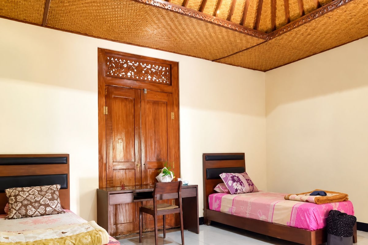 Una habitación con dos camas, un escritorio y una silla.