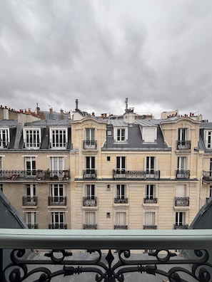 Une rangée d’immeubles à plusieurs étages, dotés de balcons, sous un ciel nuageux.