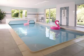 A swimming pool with two pink flamingo floats, a potted plant, and a view of greenery outside. - Holiday Home 'Ferme De Saint-rémy, En Champagne' with Private Terrace, Wi-Fi and Air Conditioning (Saint-Remy-le-Petit)