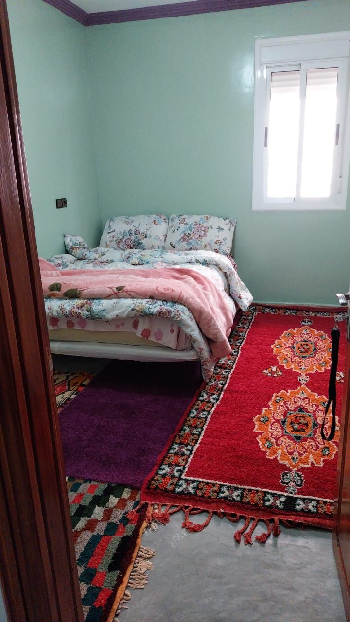 Un dormitorio con cama, ventana y puerta.