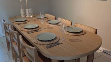 Comedor con una mesa de madera dispuesta para seis personas, rodeada de seis sillas.