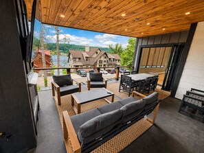 An outdoor seating area with a view of a lake and buildings. - New Spacious Mountain Modern Home • 5 bedroom/5 Bath • Walk Wisp • Sauna/Hot Tub (McHenry)