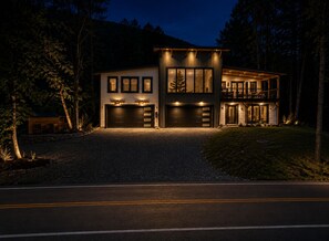 A modern two-story house with a garage, driveway, and a forested backdrop. - New Spacious Mountain Modern Home • 5 bedroom/5 Bath • Walk Wisp • Sauna/Hot Tub (McHenry)