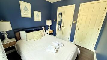 A hotel room with a bed, nightstands, a lamp, a ceiling fan, and a wardrobe.