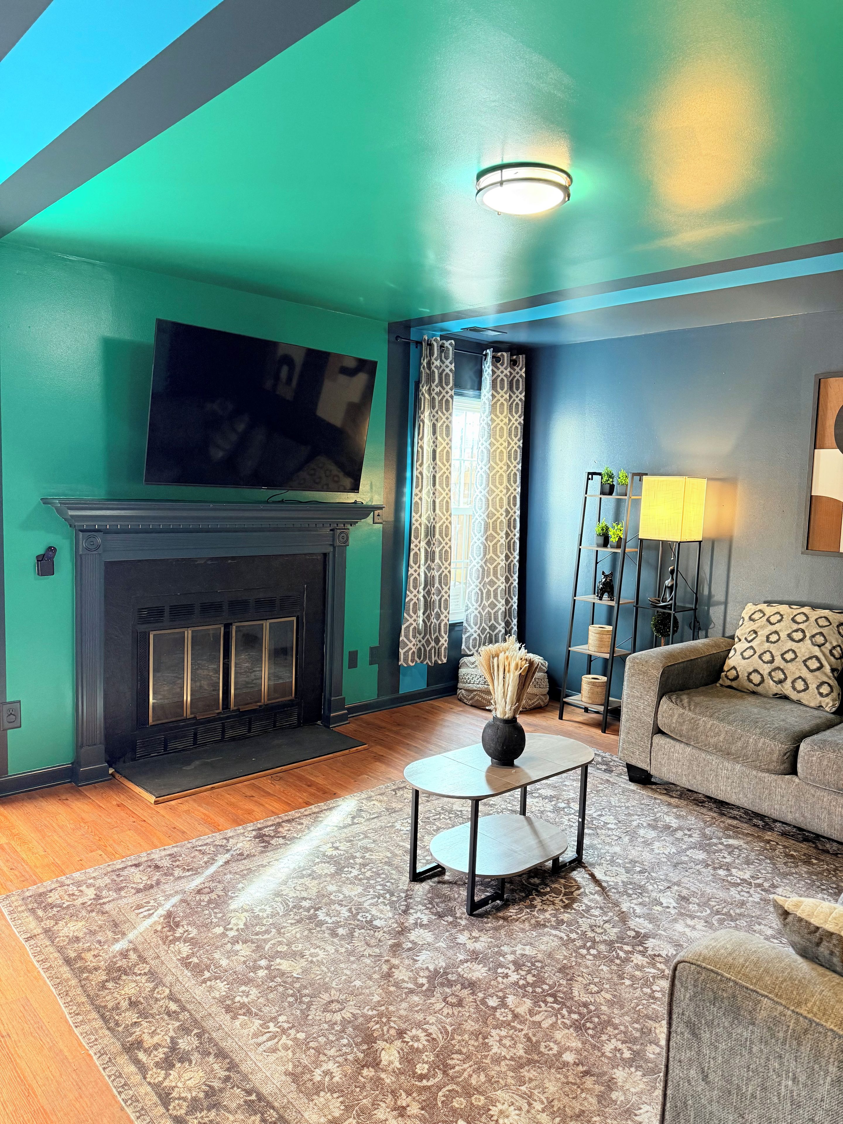 A living room with a fireplace, a sofa, a coffee table, and a television.