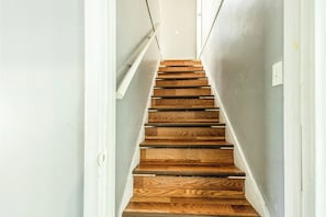 Eine Holztreppe mit weißen Wänden und einem hellen Boden.