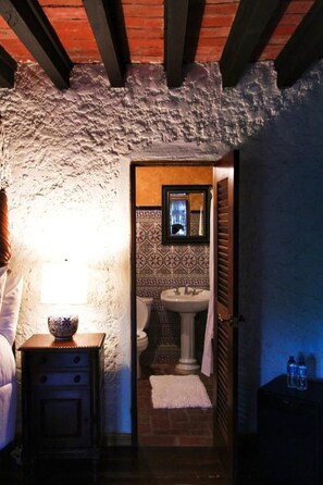 A narrow hallway leading to a bathroom with a tiled wall, a sink, and a window. - Hacienda Siesta Alegre (Río Grande)