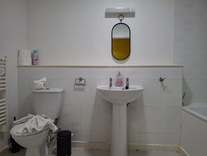 Ein Badezimmer mit Toilette, Waschbecken und Spiegel.