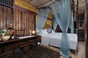 Una habitación tradicional con cama, escritorio y mesita de noche.