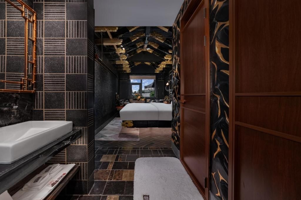 A modern bathroom with a large mirror, a white sink, and a wooden cabinet.