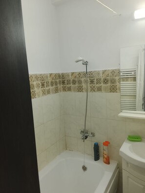 A bathroom with a shower, a toilet, a sink, and a mirror.