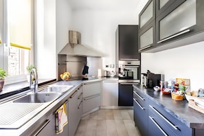 A modern kitchen with stainless steel appliances, a built-in oven, and a large window providing natural light. - Apartment 'Sea & Soul Genova' with Wi-Fi and Air Conditioning (Genova)