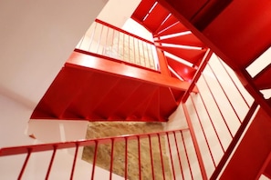 Eine Wendeltreppe mit roten Geländern und beigen Stufen.
