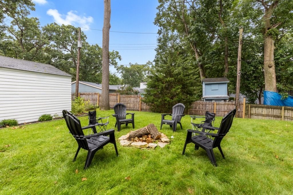 Un jardin avec un foyer et du mobilier d’extérieur.
