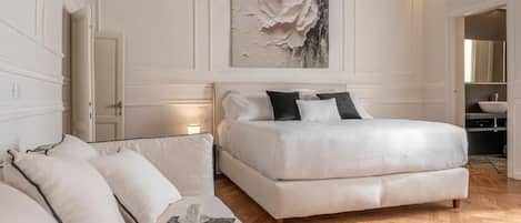 Un dormitorio con una cama grande, un sofá y un cuadro en la pared.