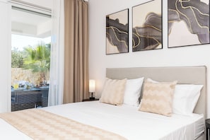 Ein Hotelzimmer mit einem Bett, einem Nachttisch, einer Lampe und Kunstwerken an der Wand.