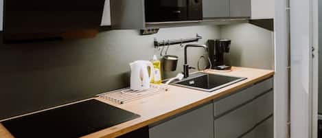 A modern kitchen with a built-in oven, a microwave, and a sink.