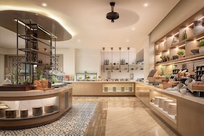 Cozinha moderna com ilha curva, estantes embutidas e diversos utensílios de cozinha.