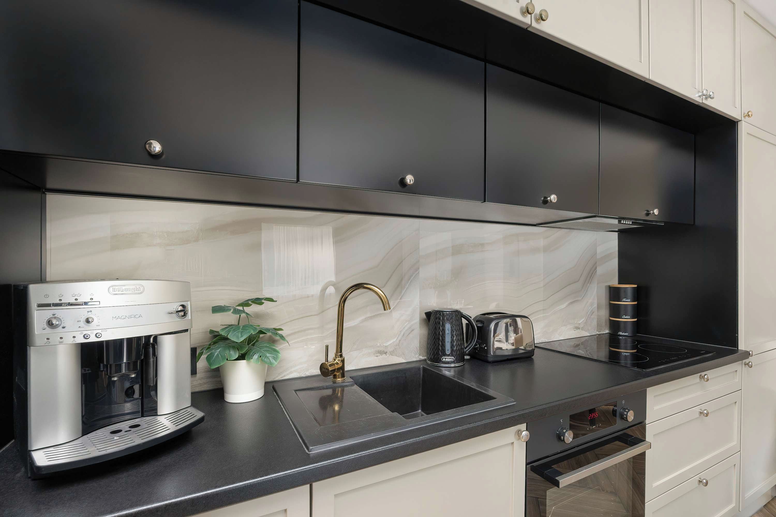 A modern kitchen with a coffee machine, a kettle, and a toaster on the counter.
