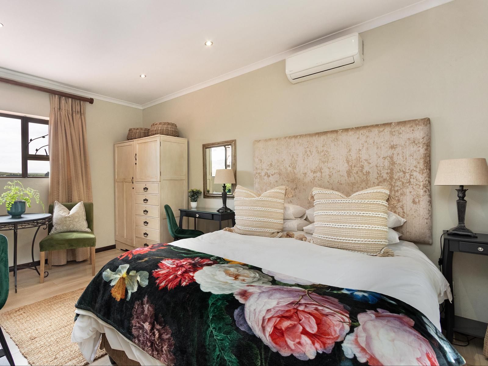 A bedroom with a bed, a desk, a chair, a wardrobe, and a bedside lamp.