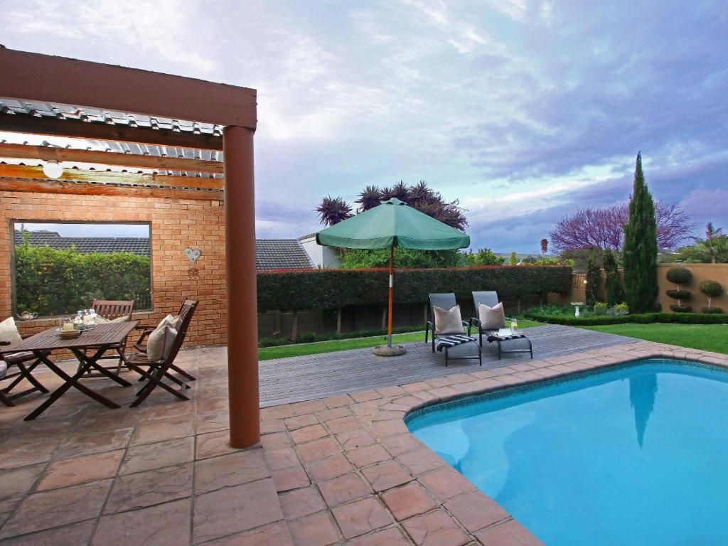 A swimming pool with a pergola and outdoor seating area.