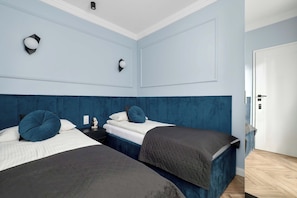 Ein Zimmer mit zwei Betten, einem Nachttisch und einer Tür.