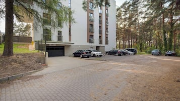 Un edificio de varios pisos con un área de estacionamiento al frente.