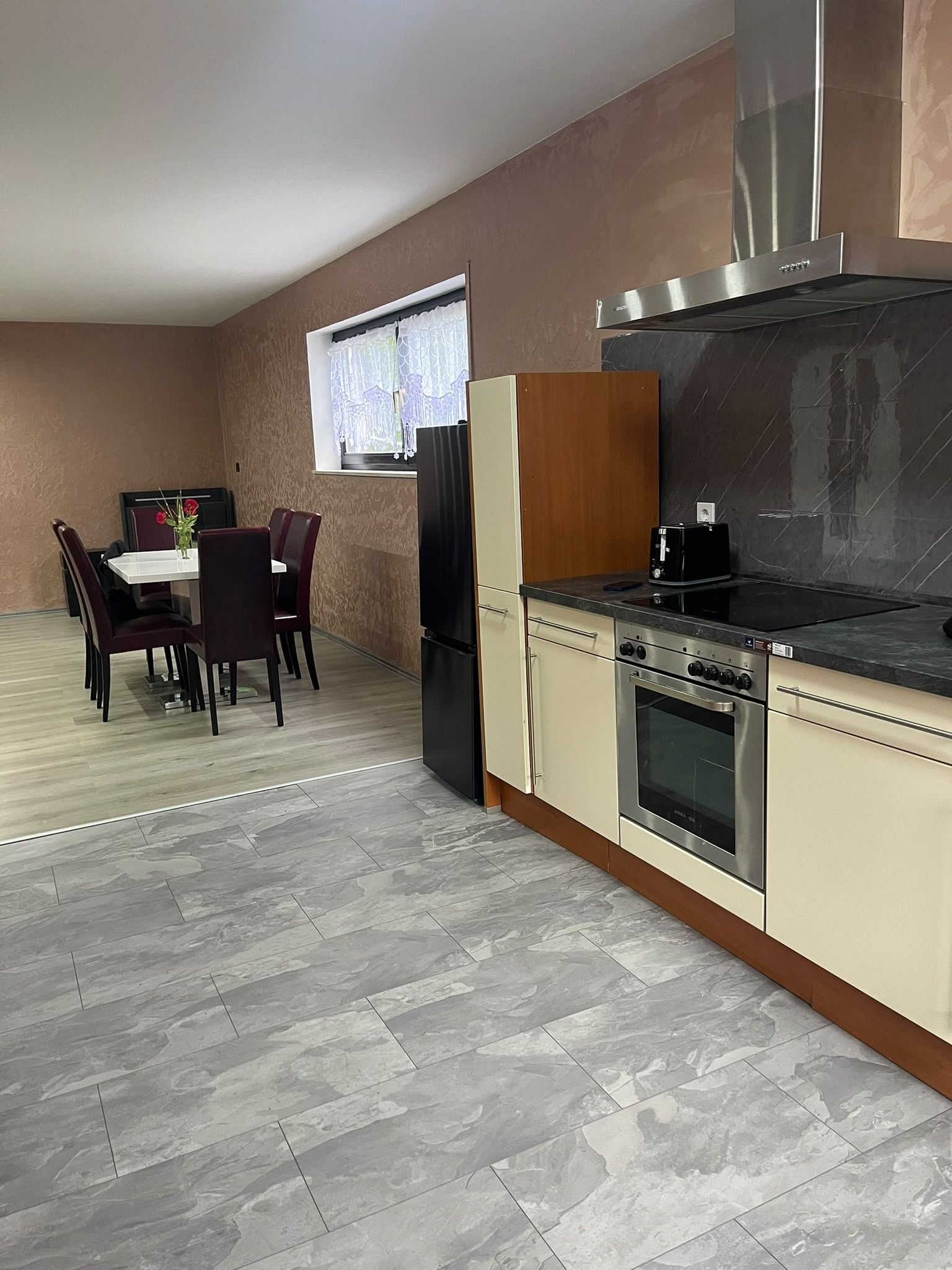 Eine kompakte Küche mit Herd, Backofen und einem Essbereich mit Stühlen und Tisch.