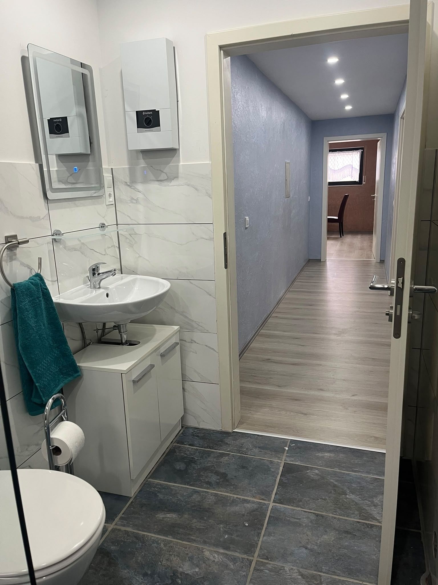 Ein modernes Badezimmer mit Waschbecken, Spiegel und Toilette.