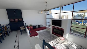 A living room with a sofa, chairs, a fireplace, and a TV.