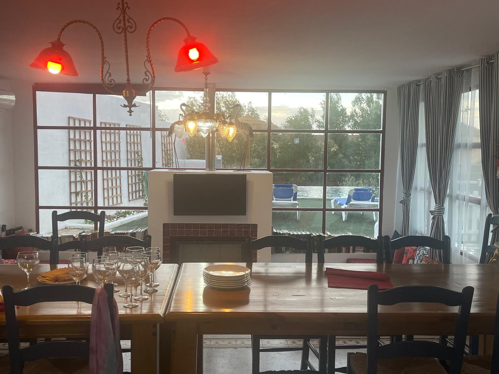 A dining area with a fireplace, large windows, and a view of the outdoors.