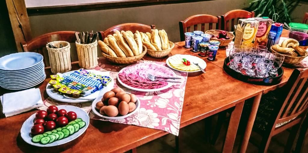 Una tavola imbandita con diversi cibi e bevande, tra cui pane, uova e altre bevande.