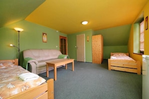 Quarto com cama, sofá, uma mesinha e guarda-roupa.