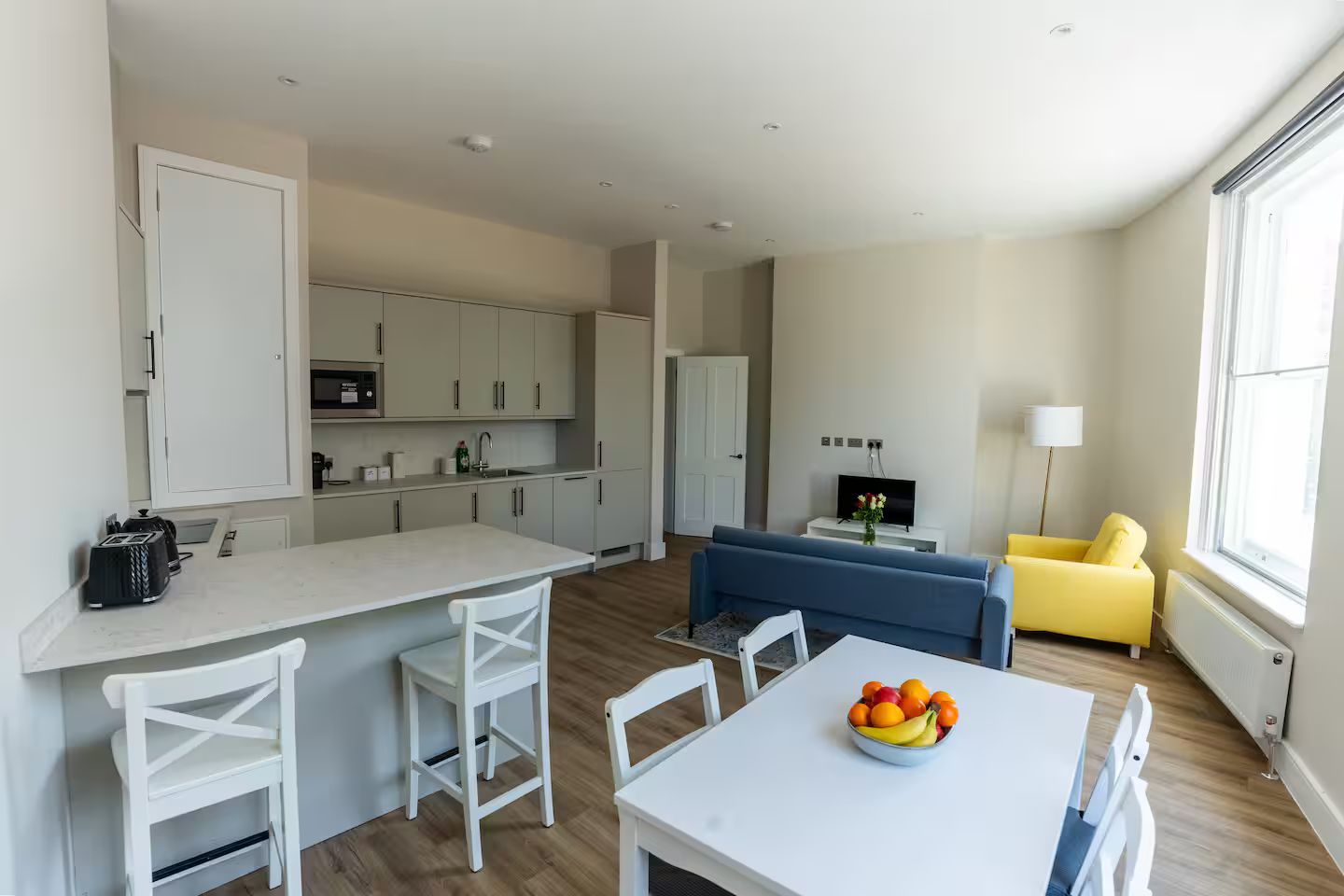 A modern apartment with a kitchen, dining area, and living room.