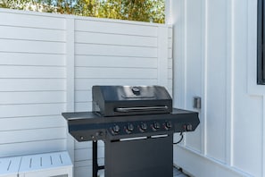 Un barbecue doté de plusieurs brûleurs, d’un panneau de commande et d’une cheminée.
