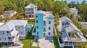 A multi-story residential building with a swimming pool and a covered patio area. - Yachtmaster - Ocean View Rooftop Deck - Pool (Santa Rosa Beach)